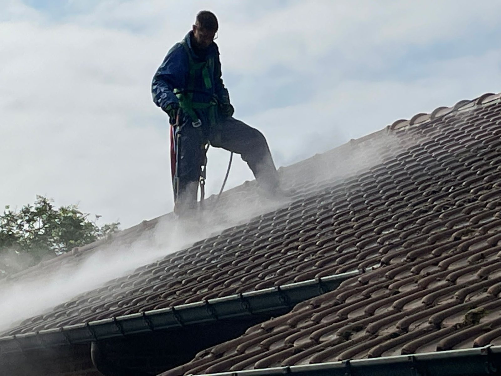 Medewerker reinigt een dak met warm water